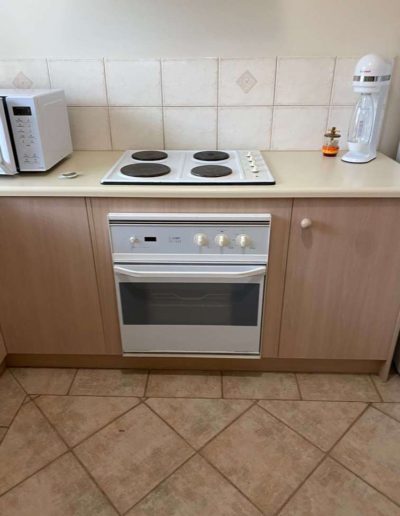 Before a new install - white underbench oven & solid hot plate replaced with a Stainless Steel oven with stainless steel trim at the bottom & ceramic cooktop