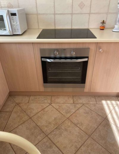 White underbench oven & solid hot plate replaced with a Stainless Steel oven with stainless steel trim at the bottom & ceramic cooktop