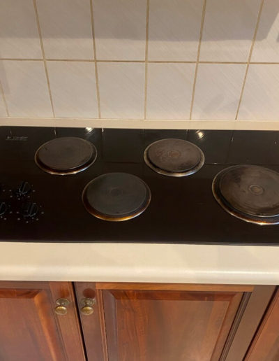 Before & after photos of replacing old solid hotplates with a new Westinghouse ceramic cooktop.